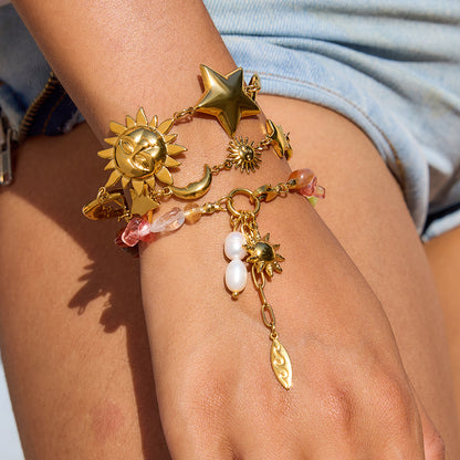 Model wearing layered gold and gemstone bracelets in bright sunlight