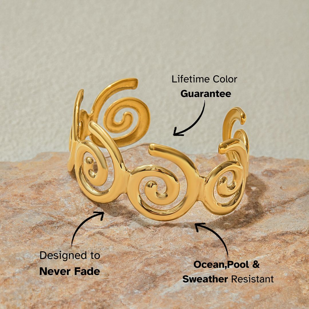 Swirl arm cuff bracelet placed on textured stone background for coastal styling