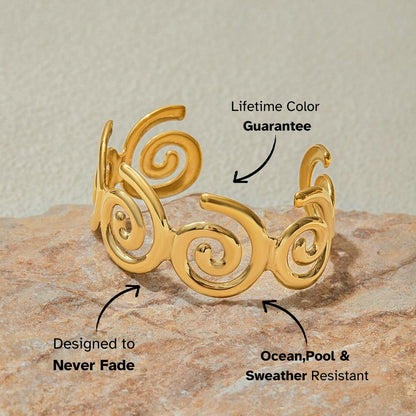 Swirl arm cuff bracelet placed on textured stone background for coastal styling