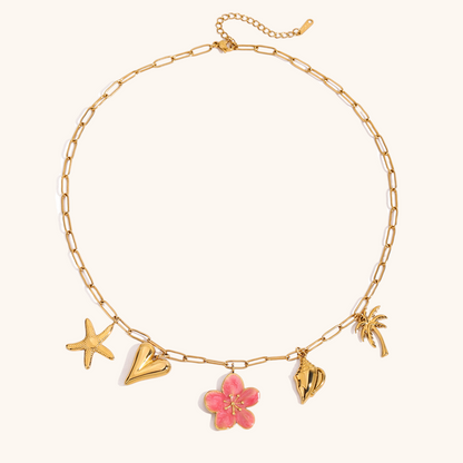 Close-up of pink flower pendant necklace with golden tropical charms