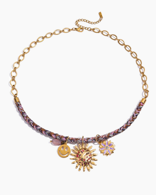 Necklace with colorful braided cord and decorative charms on a white background