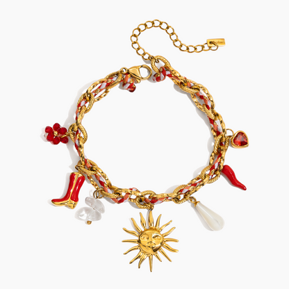 Gold bracelet with various charms including a sun, high heels, and a chili pepper on a white background.