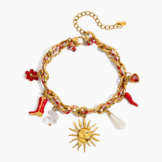 Gold bracelet with various charms including a sun, high heels, and a chili pepper on a white background.