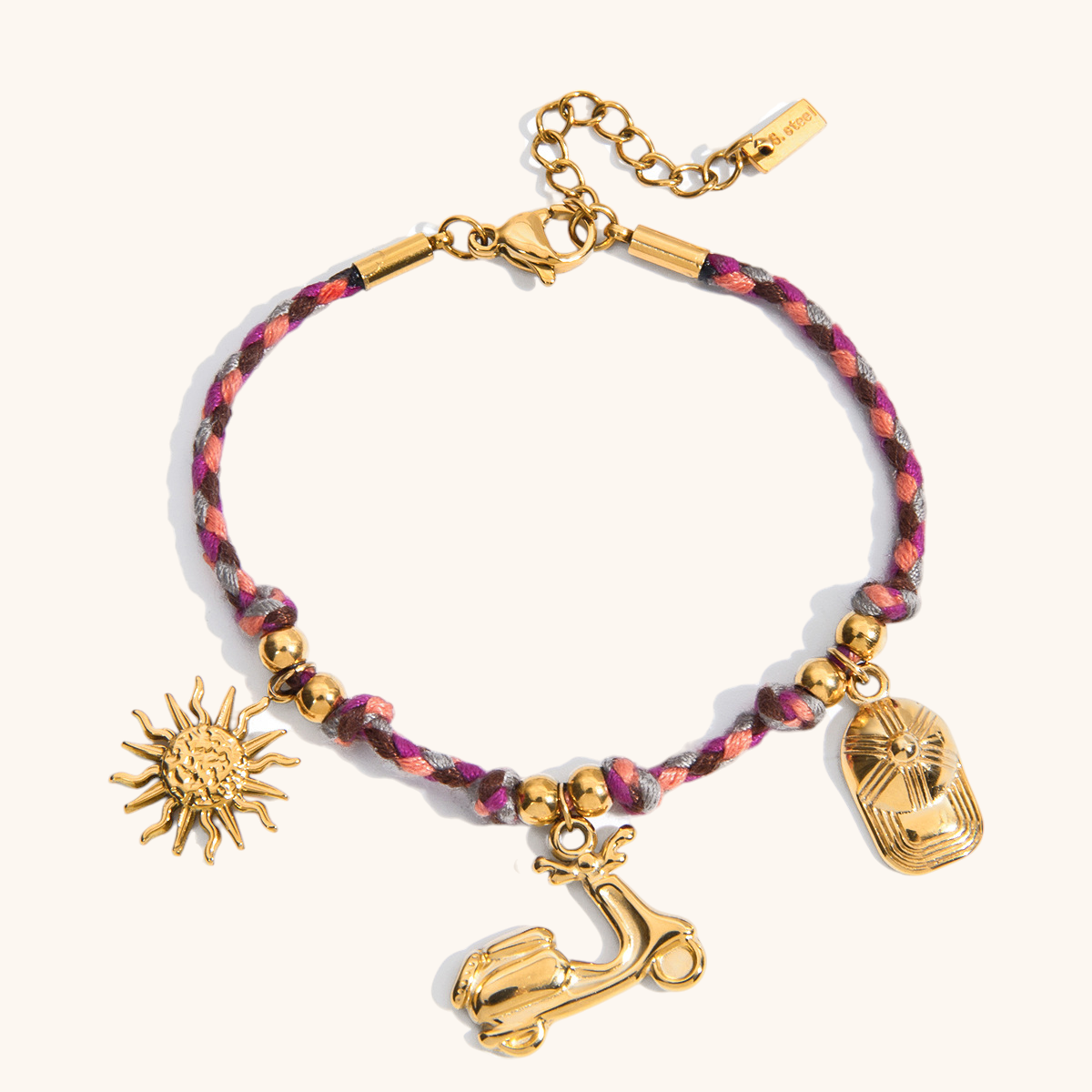 Pink and purple rope bracelet with sun, scooter, and hat gold charms