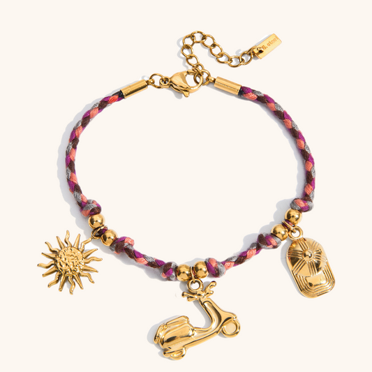 Pink and purple rope bracelet with sun, scooter, and hat gold charms