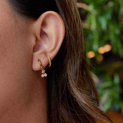 Girl wearing cherry gold hoop earrings with messy hair, shot outdoors_MiFJewelry