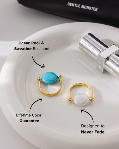 Two gold rings with gemstones on a white plate, with text highlighting features like ocean pool weather resistance and lifetime color guarantee.
