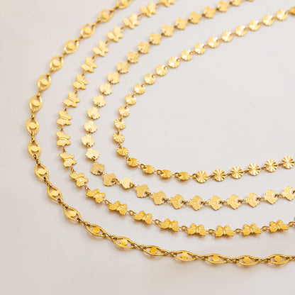 Multiple gold shell and motif chokers styled together for a layered summer look