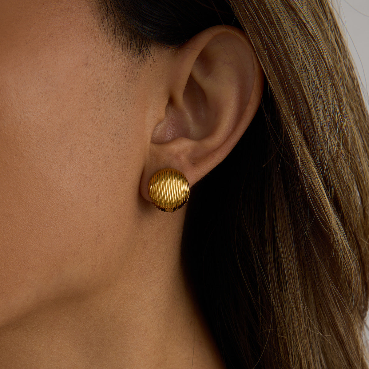 Model showing classic gold clip-on earrings, styled for everyday wear, sleek hairstyle