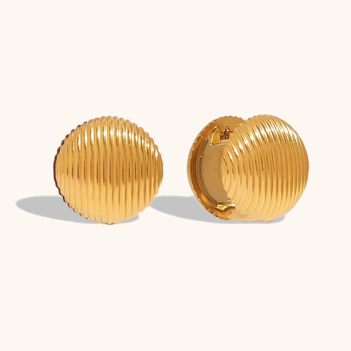 Gold dome clip-on earrings with ribbed texture, minimal studio lighting on white background