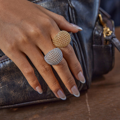 Woman wearing gold and silver chunky rings by a leather bag