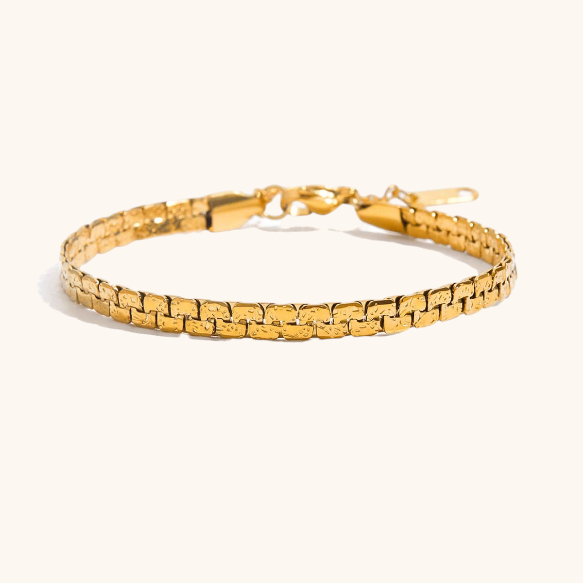 Close-up of textured gold link bracelet on white background