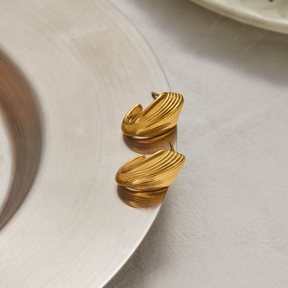Retro shell texture gold earrings on silver plate with soft lighting