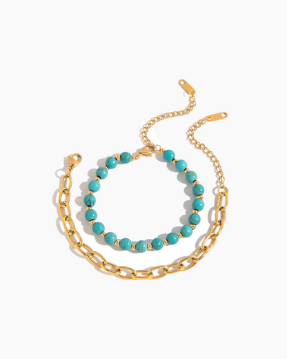 Two bracelets on a white background, one gold chain and one turquoise beads.