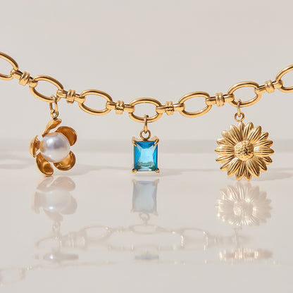 Detailed view of linked bracelet with enamel heart and blue gemstone