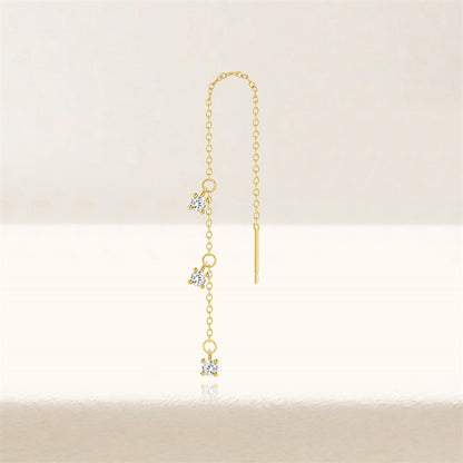 Close-up of minimalist gold threader earrings with three zircon stones on a model's ear