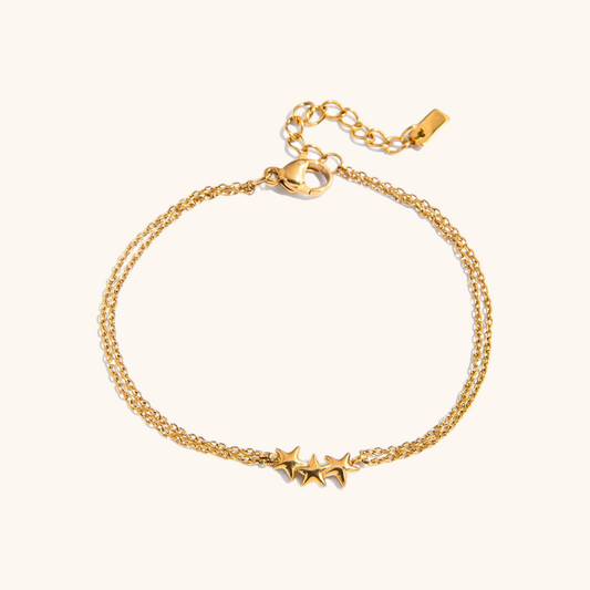 Close-up of gold triple star charm bracelet with double chain