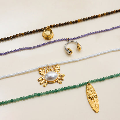 Surfboard pendant necklace worn with beach outfit