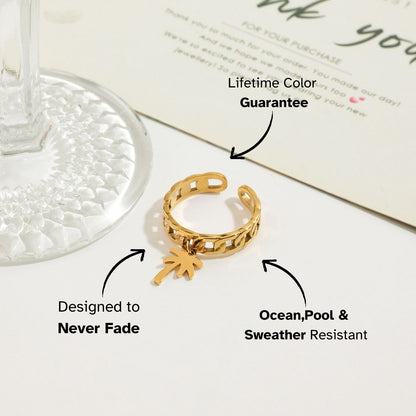 Palm pendant gold chain ring placed beside a drink glass and thank you card