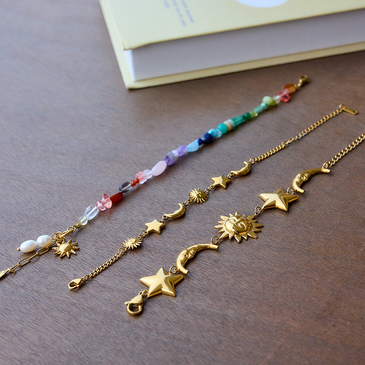  Rainbow gemstone bracelet with pearls and sun charm displayed with summer accessories