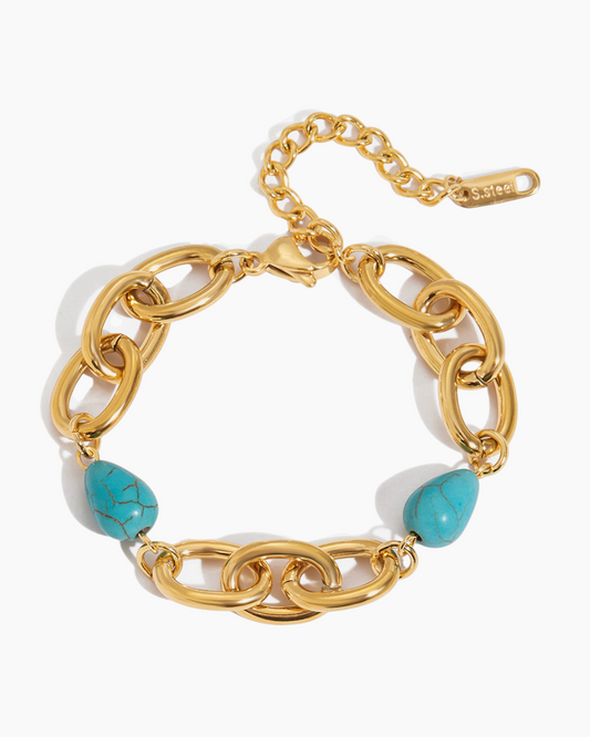 Gold chain bracelet with turquoise beads on a white background