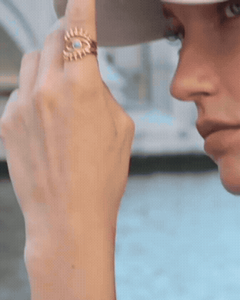 Fashion look with woman wearing evil eye ring, gold chain necklace, and matching bracelet.