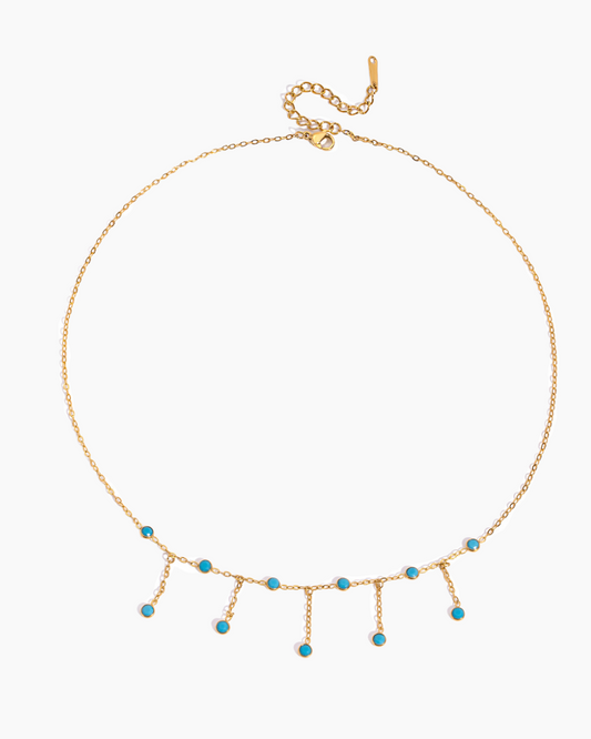 Gold necklace with turquoise beads on a white background
