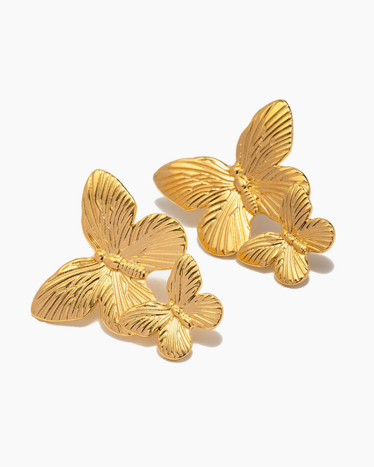 Gold butterfly earrings on a white background