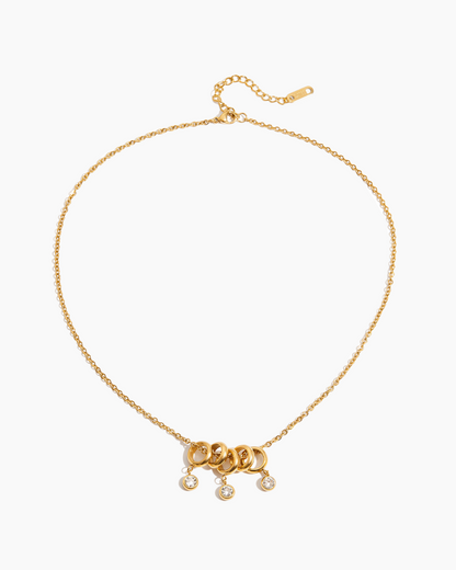 Gold necklace with a clasp and small pendants on a white background