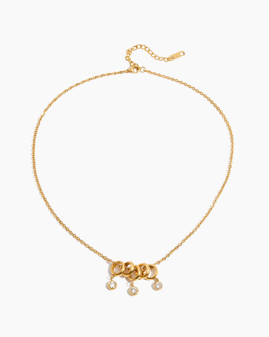 Gold necklace with a clasp and small pendants on a white background