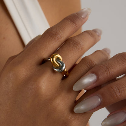 Close-up of dual-tone twisted knot ring on woman's hand
