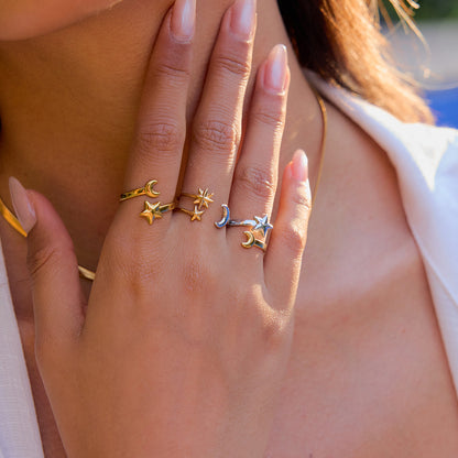 Stackable star and moon rings on female hand outdoors
