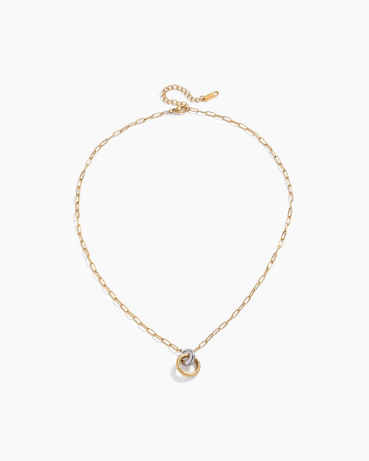 Gold necklace with a heart-shaped pendant on a white background