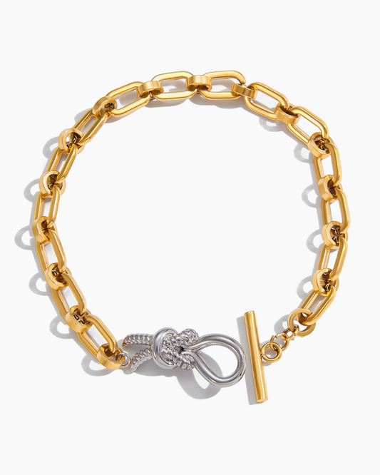 Gold chain bracelet with a knot design and clasp on a white background