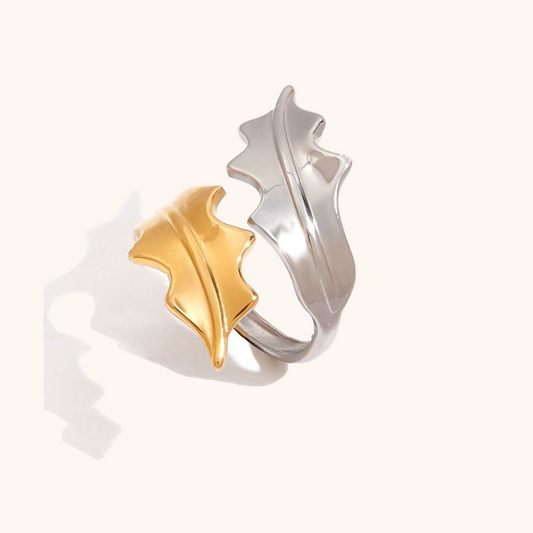 Close-up of gold and silver adjustable leaf ring on white background