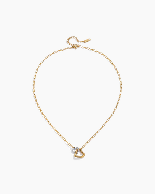 Gold necklace with a heart-shaped pendant on a white background