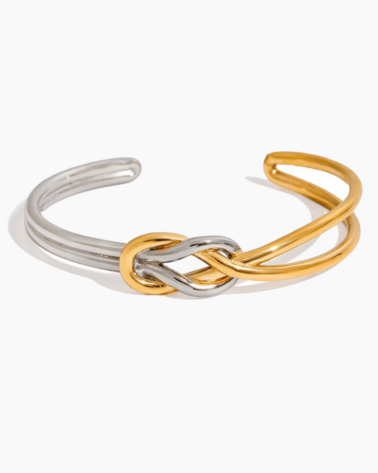 Bangle with interlocking gold and silver loops on a white background