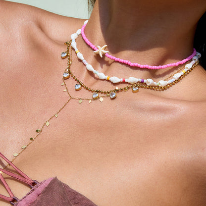 Beach-ready necklace stack featuring Y-shaped gold leaf necklace