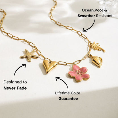 Full view of gold chain necklace with tropical pendants on neutral background