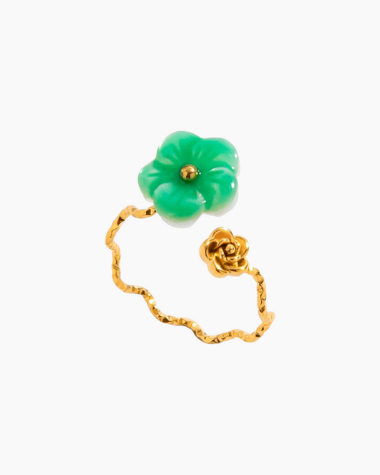 Gold ring with a green flower-shaped gemstone on a white background