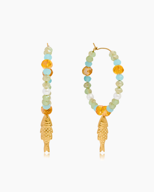 Beaded earrings with gold fish charms on a white background