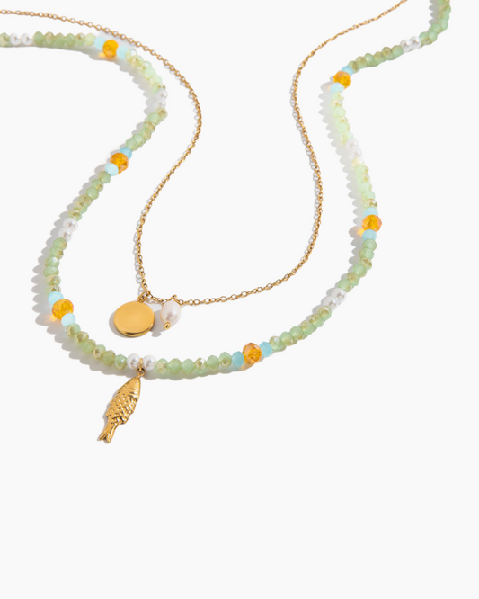 Beaded necklace with gold pendants on a white background