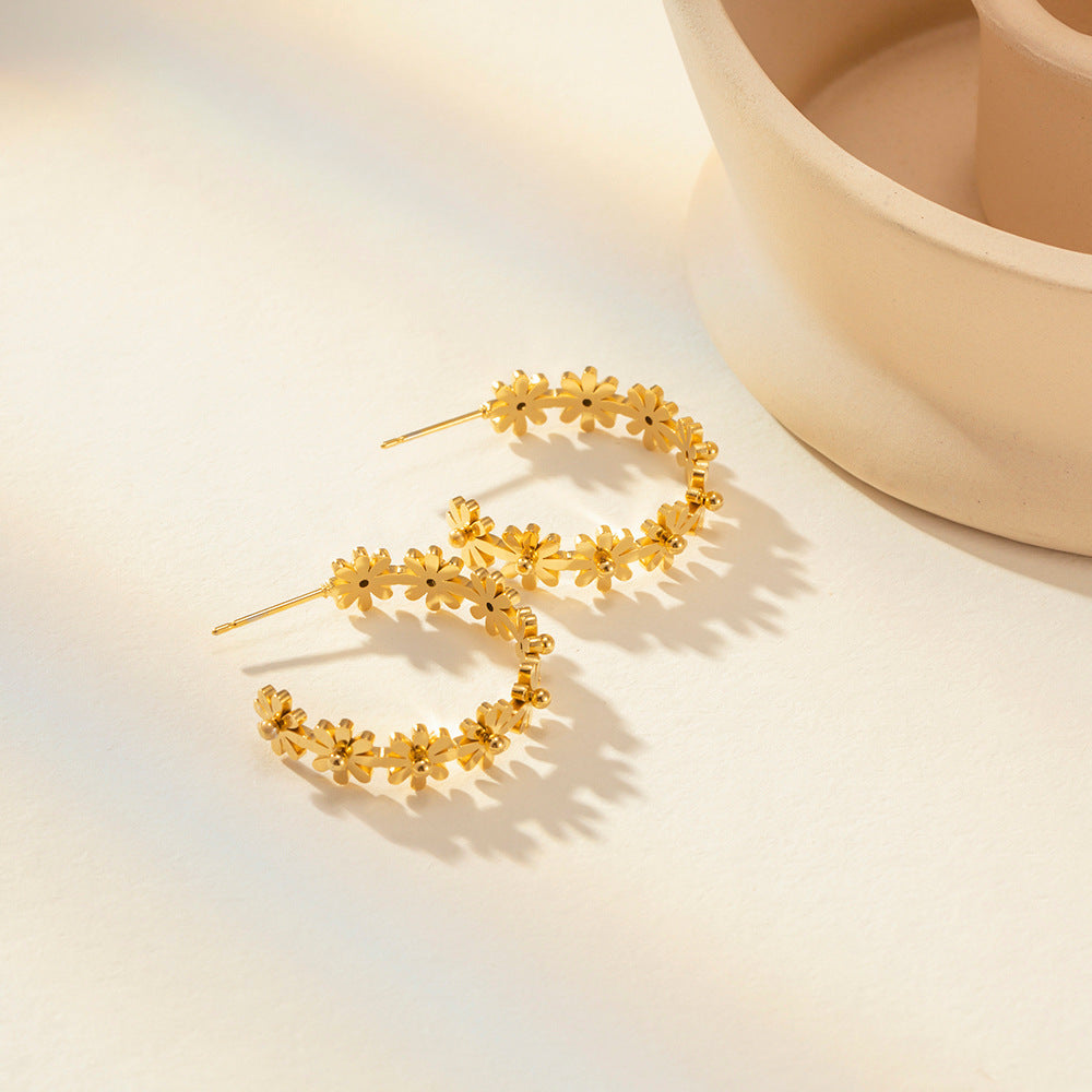 tall shot of bold gold-plated daisy earrings with staggered blossoms for a playful floral look