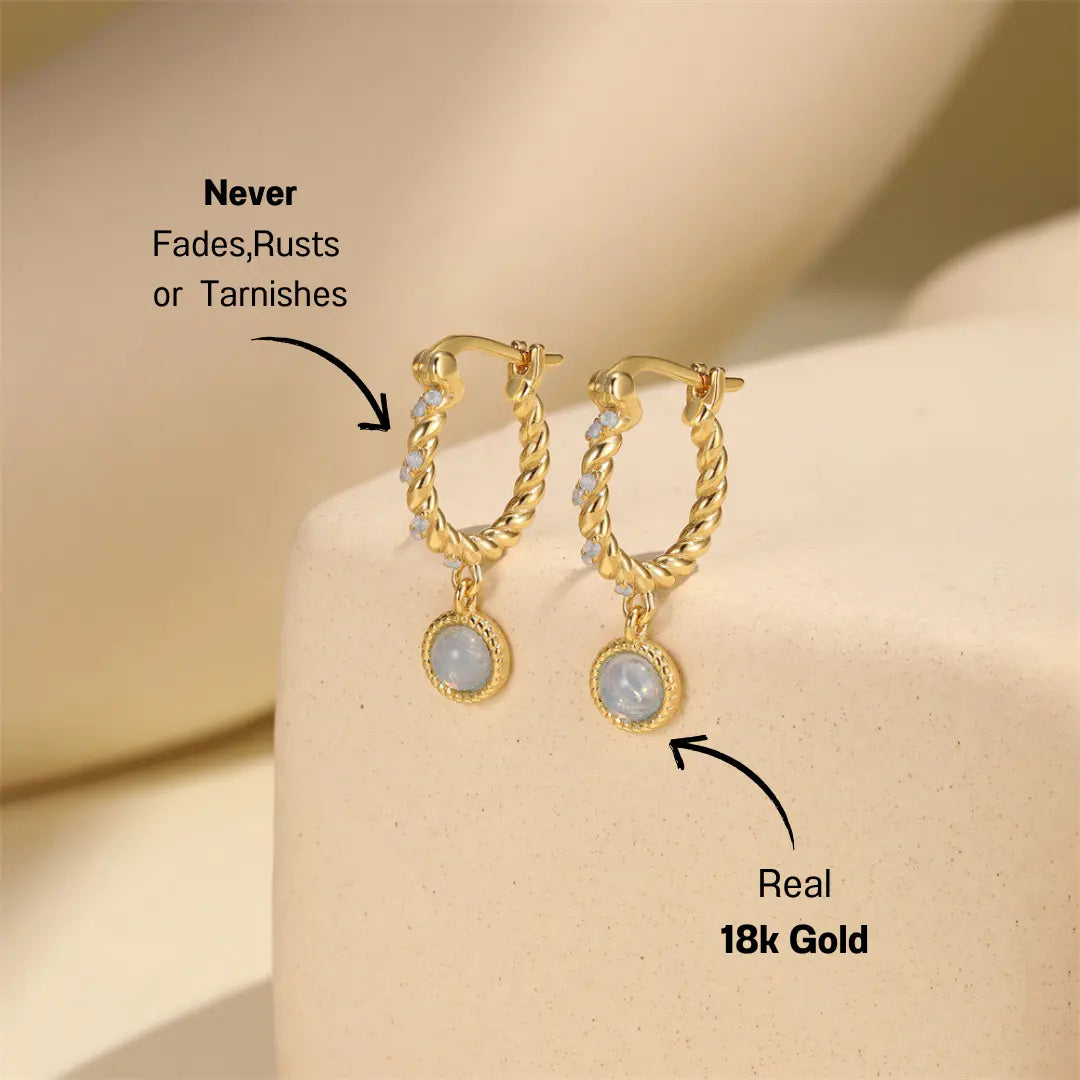 Displayed gold vintage twist hoop earrings with opal stone drop, featuring zirconia stones.