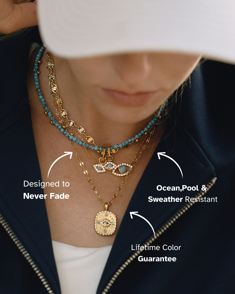 Fashion layering necklace with Evil Eye charm, gold chain and sparkling crystals, worn by woman in navy jacket.