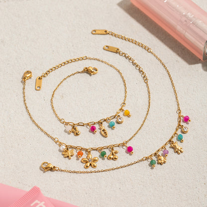 Colorful gold charm bracelet set displayed on neutral background
