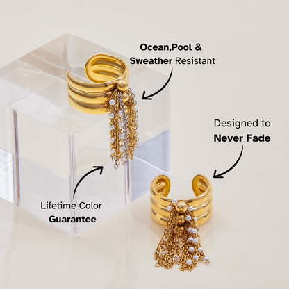 Close-up of triple band gold ring with dangling chain accents