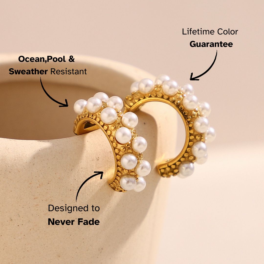 Two pearl hoops resting on a ceramic cup with light and shadow play