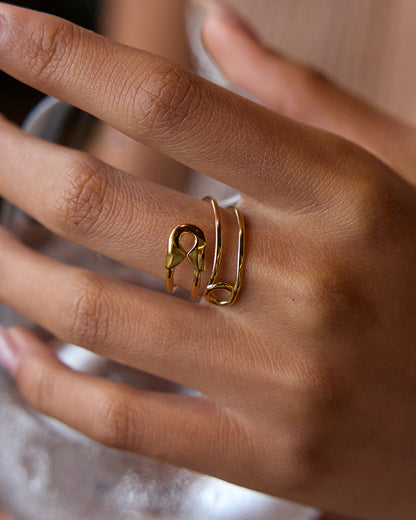 Summer shot of safety pin ring on hand holding a glass