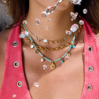 Layered necklace look with gold star choker on model